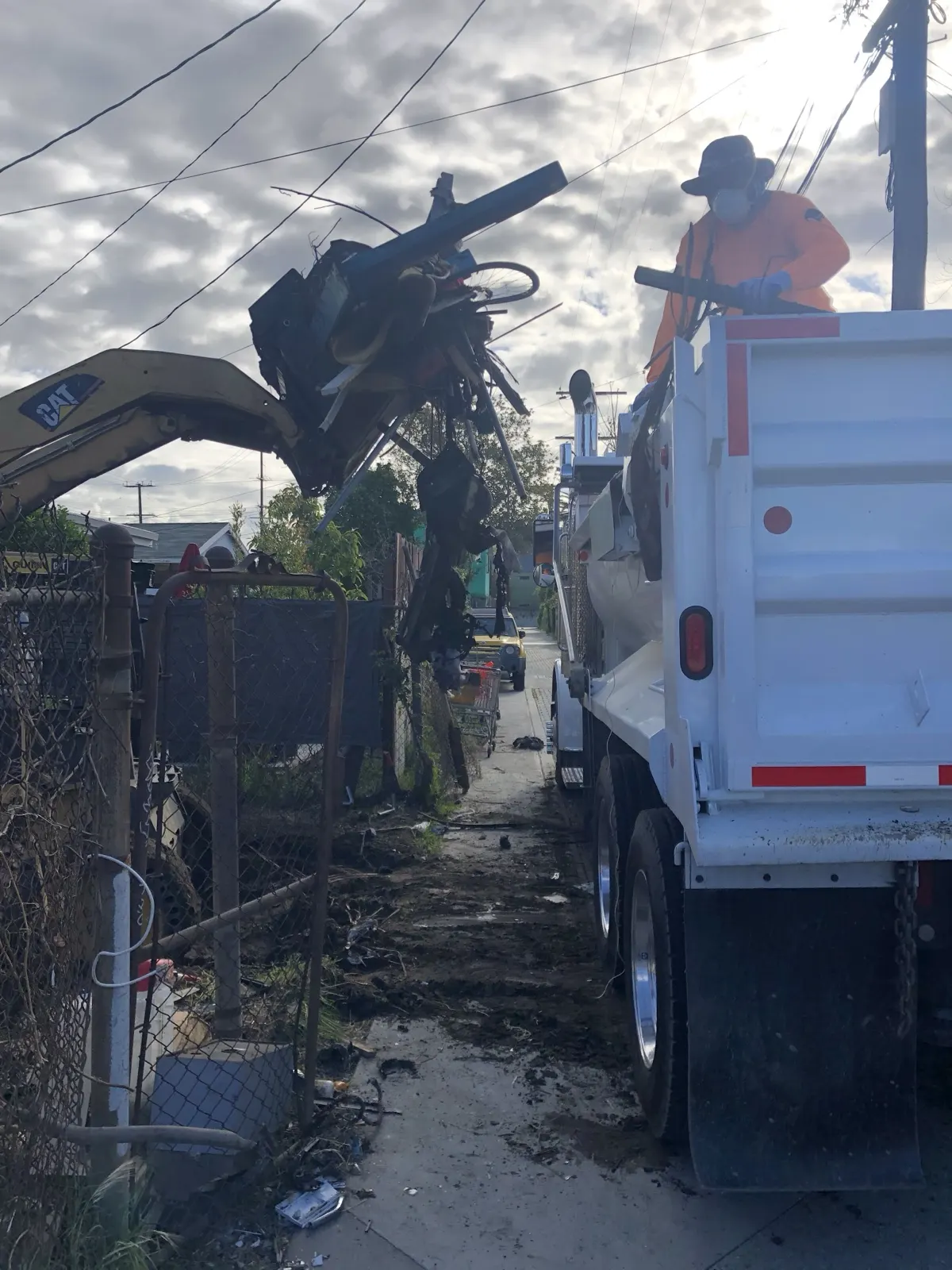 Loading debris into one of our dump trucks in a narrow alley