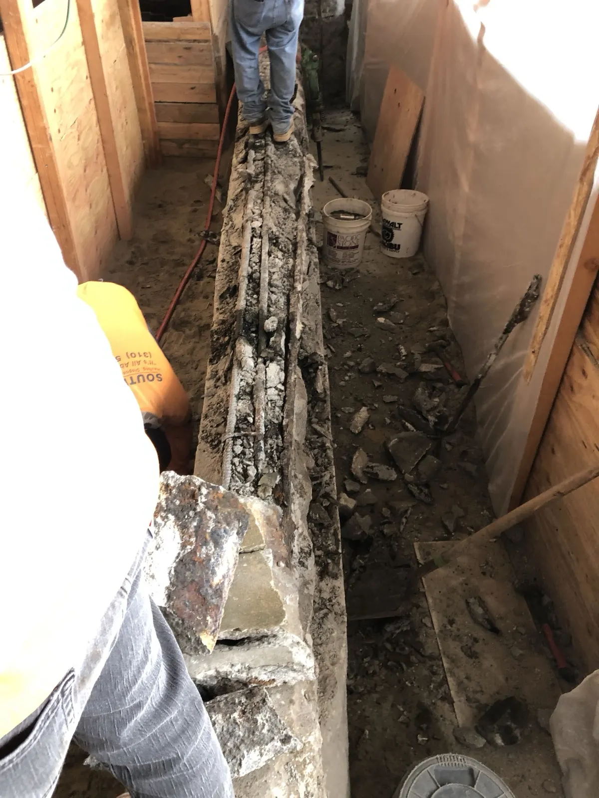 Our crew cutting the slab open along a foundation line inside a framed building